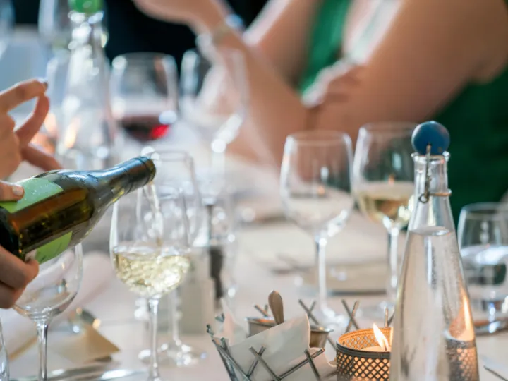 Person Pouring Wine on Clear Wine Glass