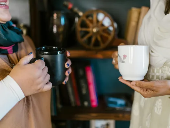 Close-up of Women Talking with Cups of Coffee in Their Hands