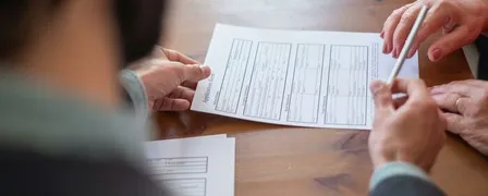 An Agent Handing a Pen to a Client