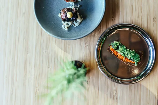 Elegant plating of gourmet dishes on wooden table, showcasing fine dining artistry.