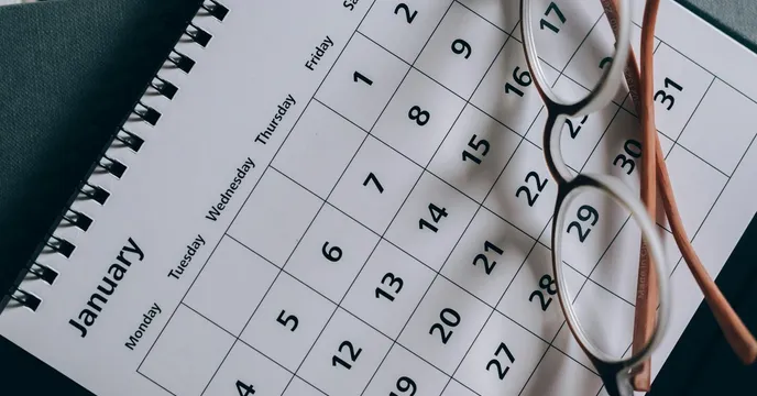 A close-up of a January calendar with eyeglasses
