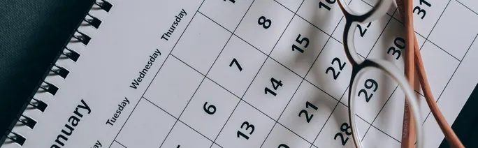 A close-up of a January calendar with eyeglasses
