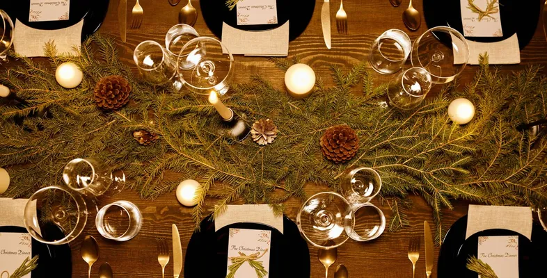 Elegant Christmas dinner table with candles, pine