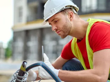 Adjustment. Young adult man in protective helmet g