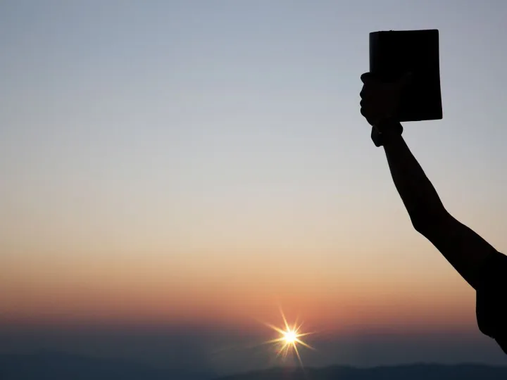 Spiritual prayer hands holding the bible