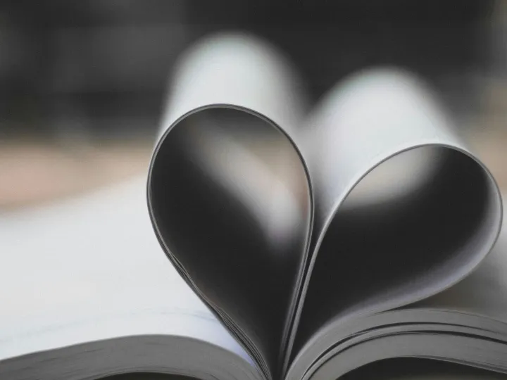 Open book pages forming a heart shape