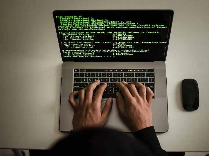 From above crop anonymous male programmer in black