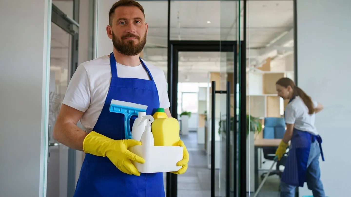 Cleaner with squeegee and supplies in a hallway